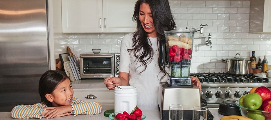 a woman blending a fruit shake